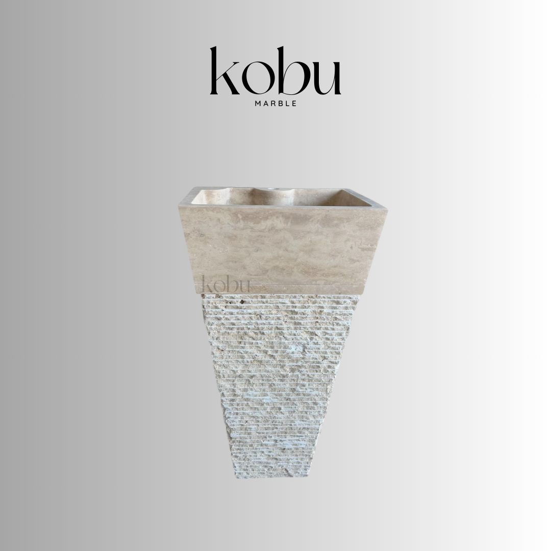 Handcrafted travertine pedestal sink with split-face texture for luxurious bathroom design
