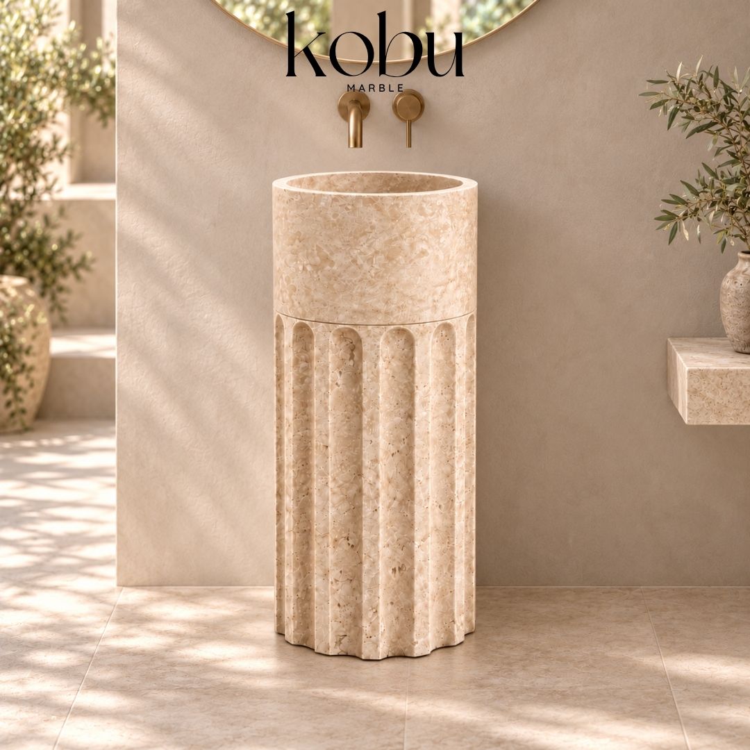 Modern two-piece travertine stone pedestal sink highlighting its handcrafted basin, sculptural base, and natural texture.