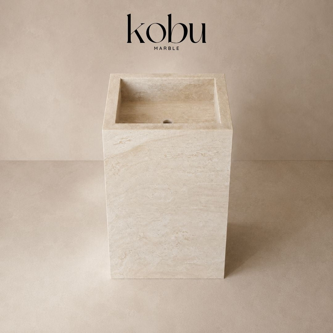 Top view of a 24-inch travertine stone pedestal sink with a carved rectangular basin and round drain opening