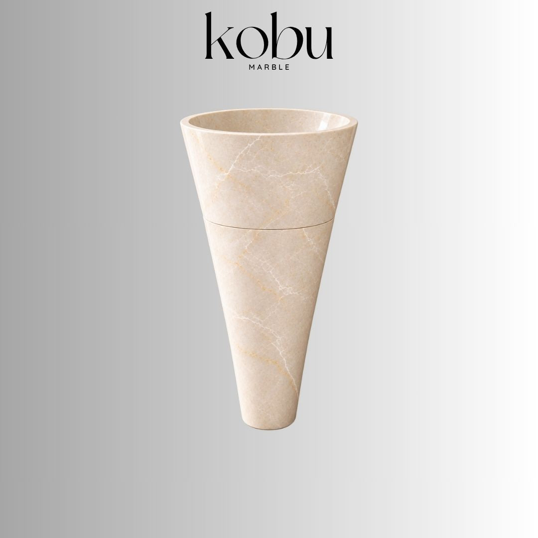 Beige marble pedestal sink with a round basin, tapered base, and natural veining.