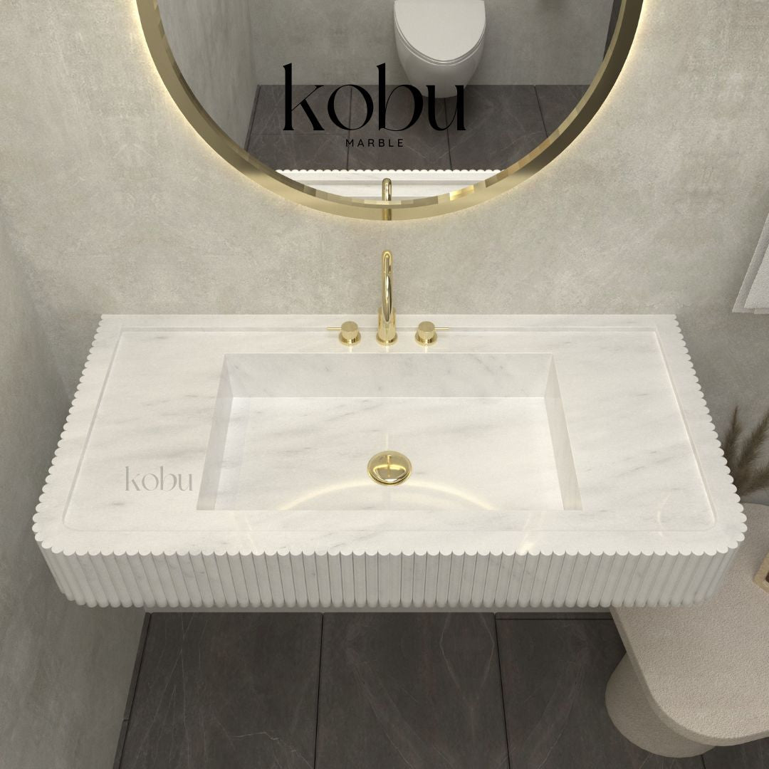 Detailed view of fluted white marble sink, highlighting handcrafted grooves and polished finish.